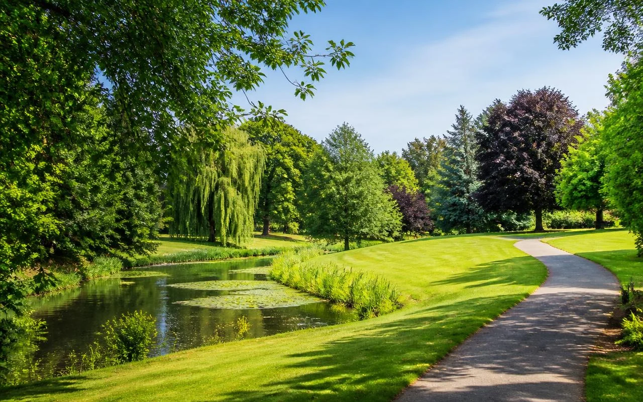 Mature trees, lawns and a pond in a public park in Bromley, south east London