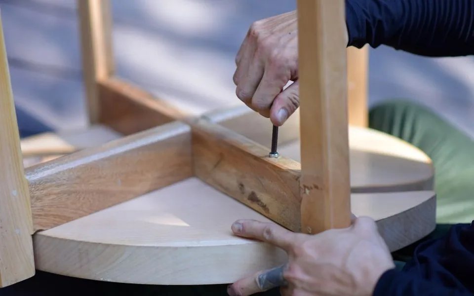 Flat-pack furniture being assembled with a screwdriver