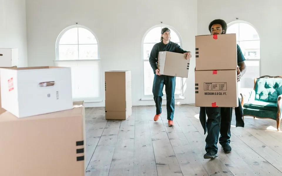 Packed boxes being carried into a property on moving day