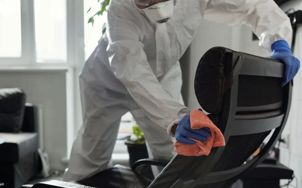Upholstered chair being cleaned by hand with a microfibre cloth